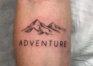 Fineline Berg Tattoo mit "ADVENTURE" tattoostudio münchen