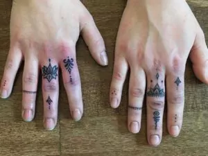 Feine Finger-Tätowierungen mit Symbolen tattoostudio münchen