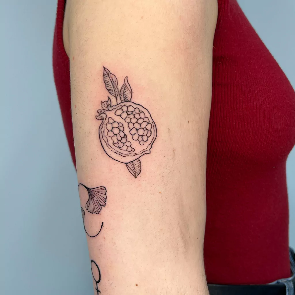 Granatapfel Tattoo am Arm - Fineline Tattoo München