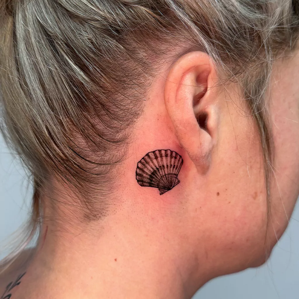 Muschel-Tattoo hinter dem Ohr - Fineline Tattoo München