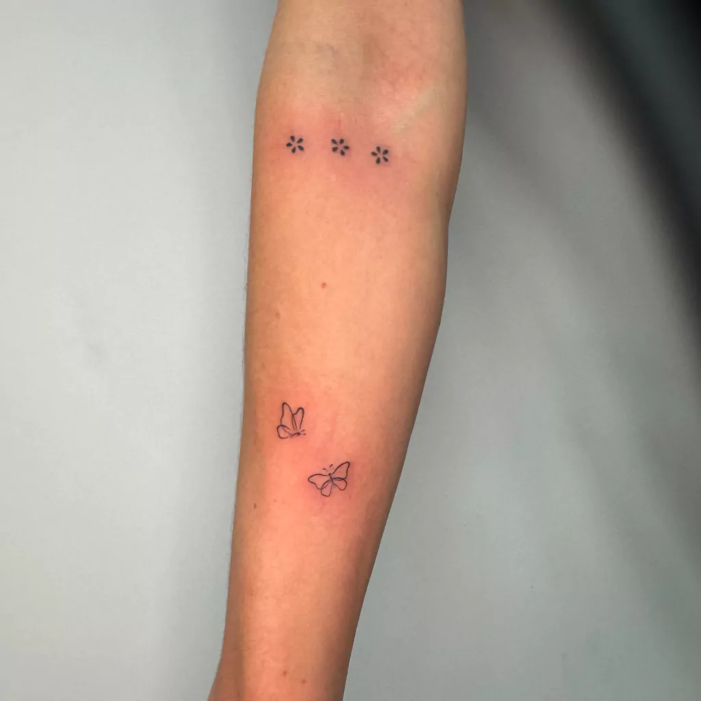 Kleine Schmetterlings-Tattoos am Arm - Fineline Tattoo München