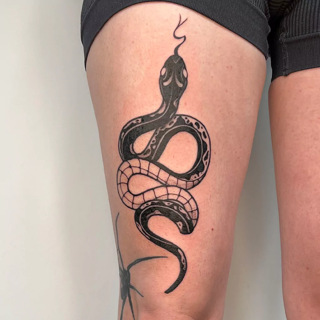blackwork tattoo Schlange am Oberschenkel